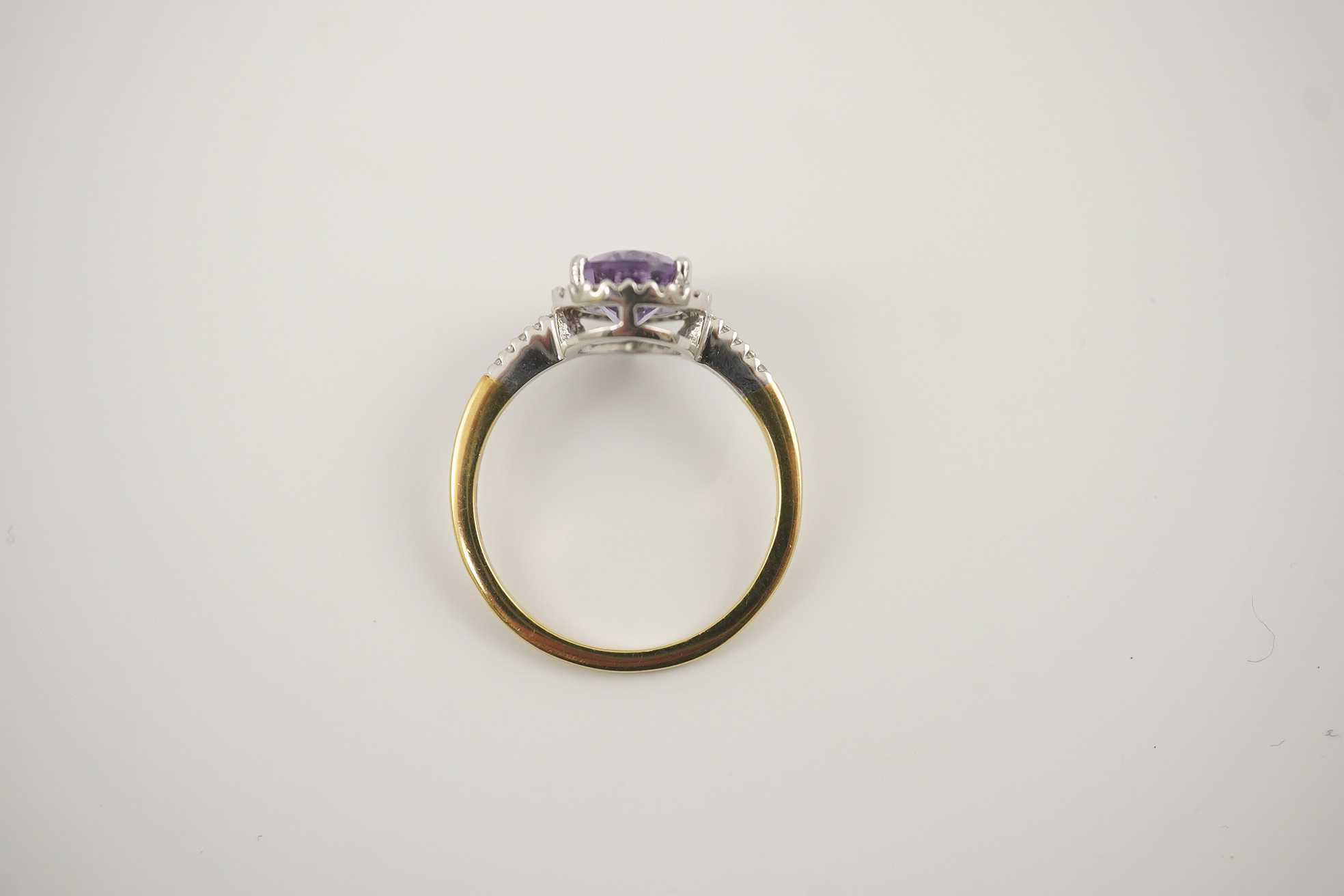 A modern 18ct gold and single stone pear cut amethyst set ring, with diamond chip set border and shoulders